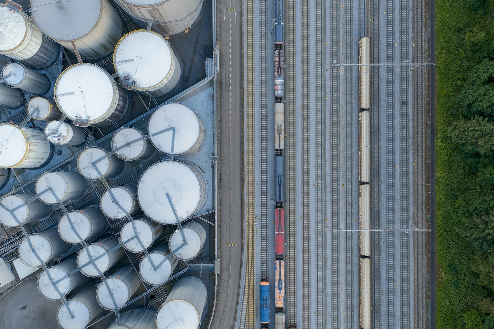 Aerial view of a storage tank farm beside rail sidings.