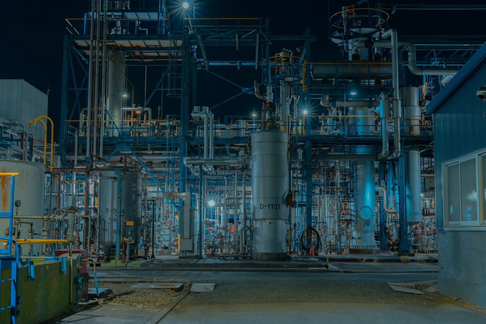 Process plant with dense pipework and steel structures at dusk.